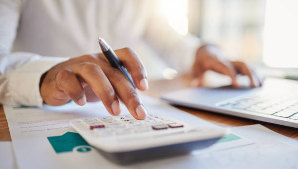 finance, accounting and fintech, a man on a computer and calculator working out his business budget strategy. businessman at his office desk, laptop, money management and financial investment online. - 金融 個(gè)照片及圖片檔