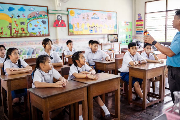 teacher giving science lesson to students in elementary school classroom - 教育 個照片及圖片檔